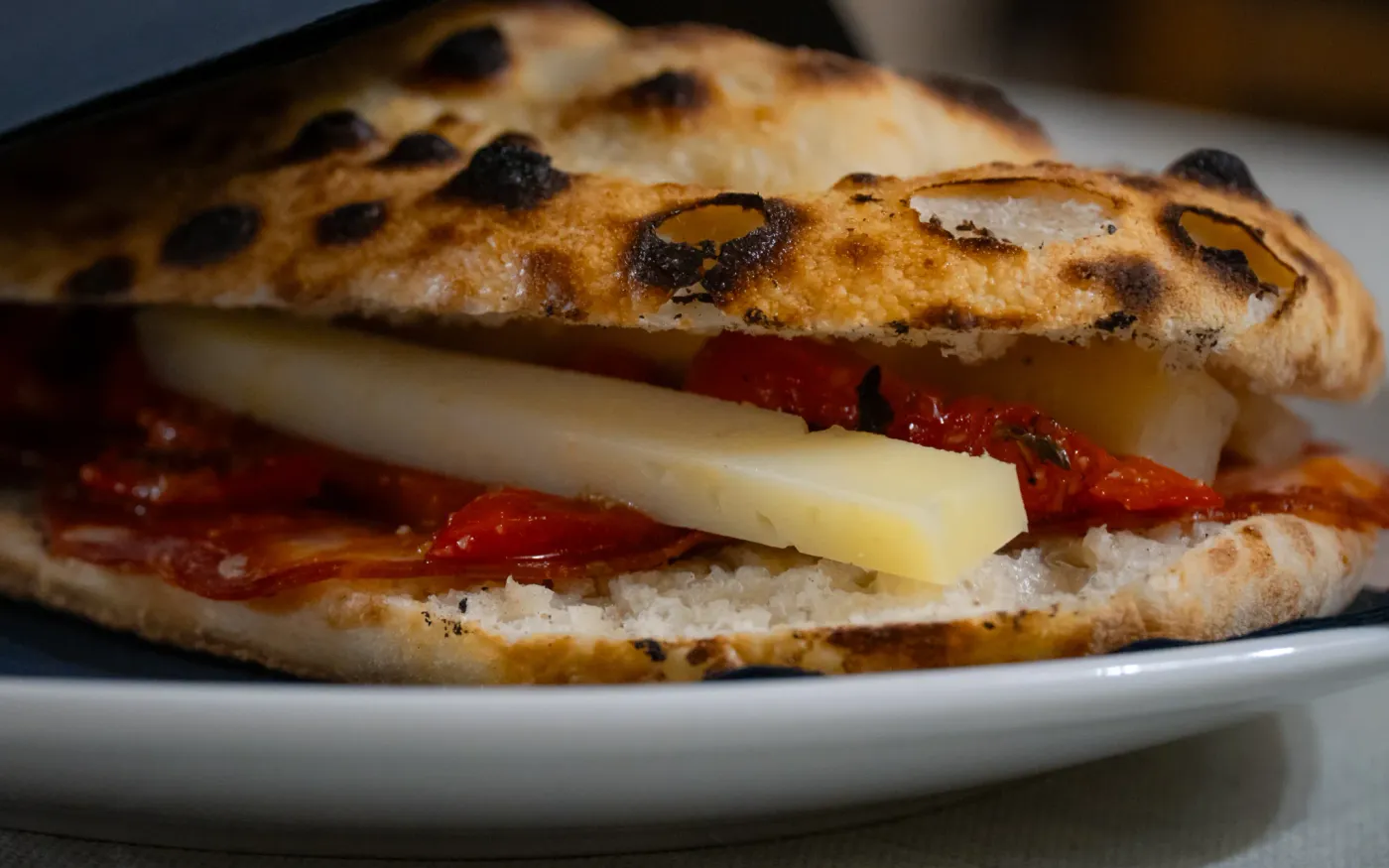Pan pizza fragrante cotta al forno e farcita con formaggio e salumi nostrani