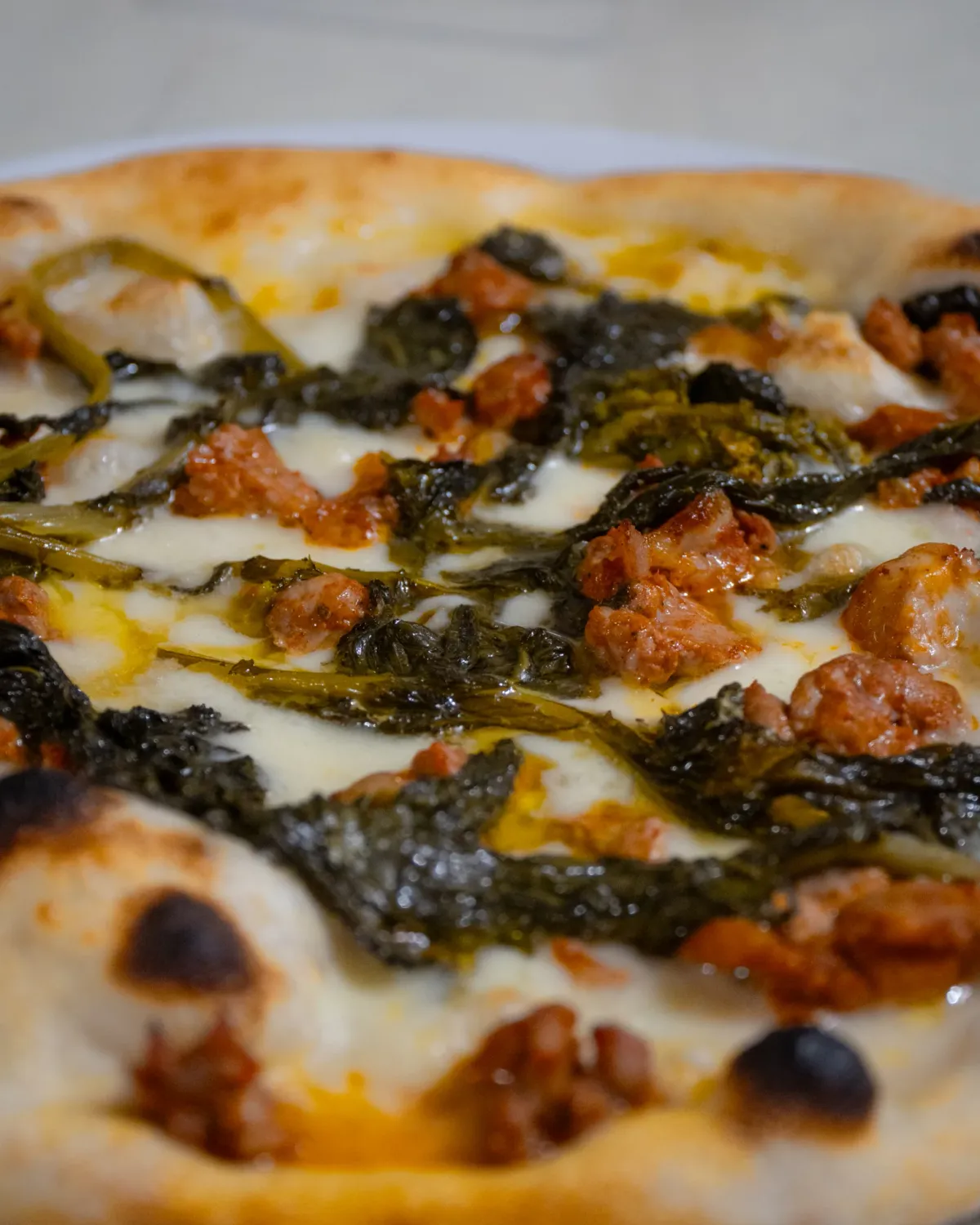 Pizza artigianale con fior di latte, friarielli e salsiccia cotta nel forno a legna